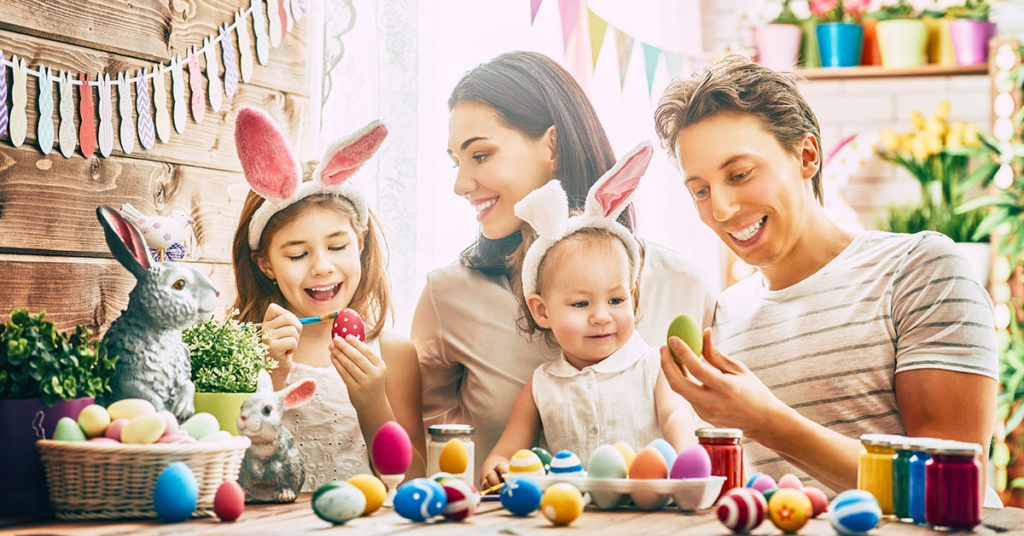 Happy family painting Easter eggs together