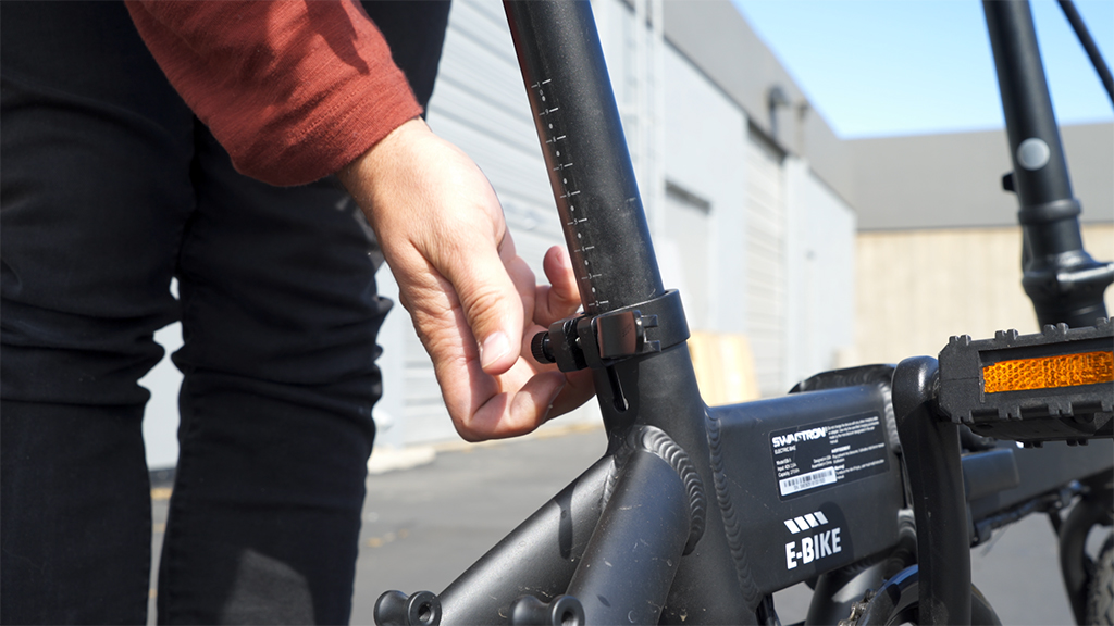 Close-up of someone tightening the seat post latch on the EB5 Pro