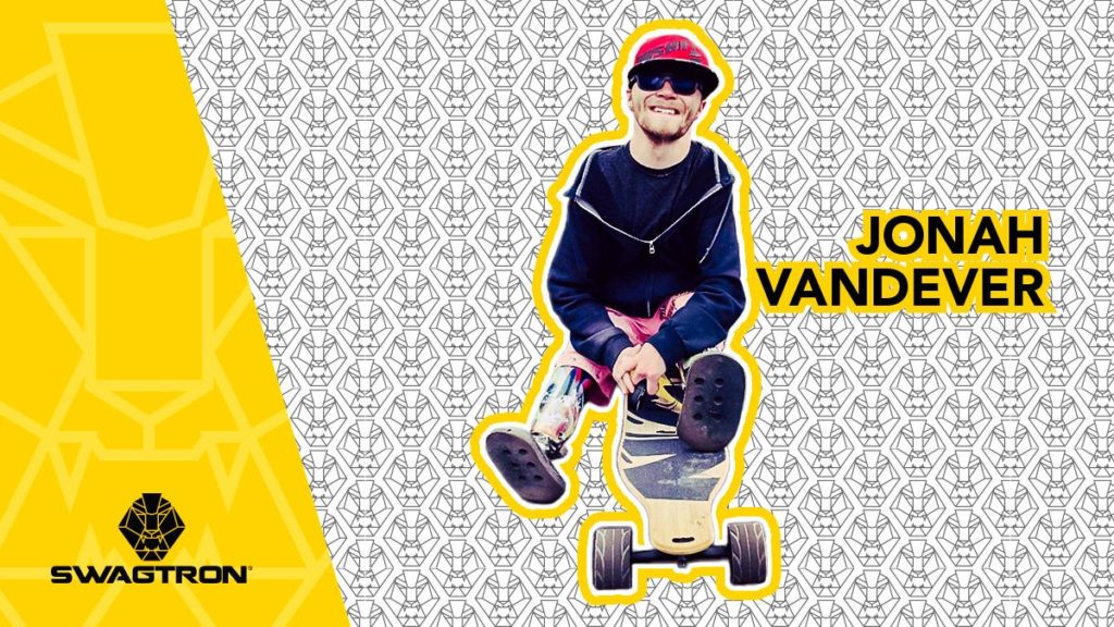 Jonah Vandever sitting on the NG2 electric longboard